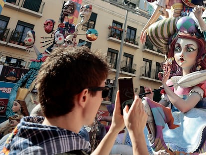 Visitantes a las Fallas de Valencia recorren y sacan fotografías de los monumentos falleros repartidos por toda la capital.