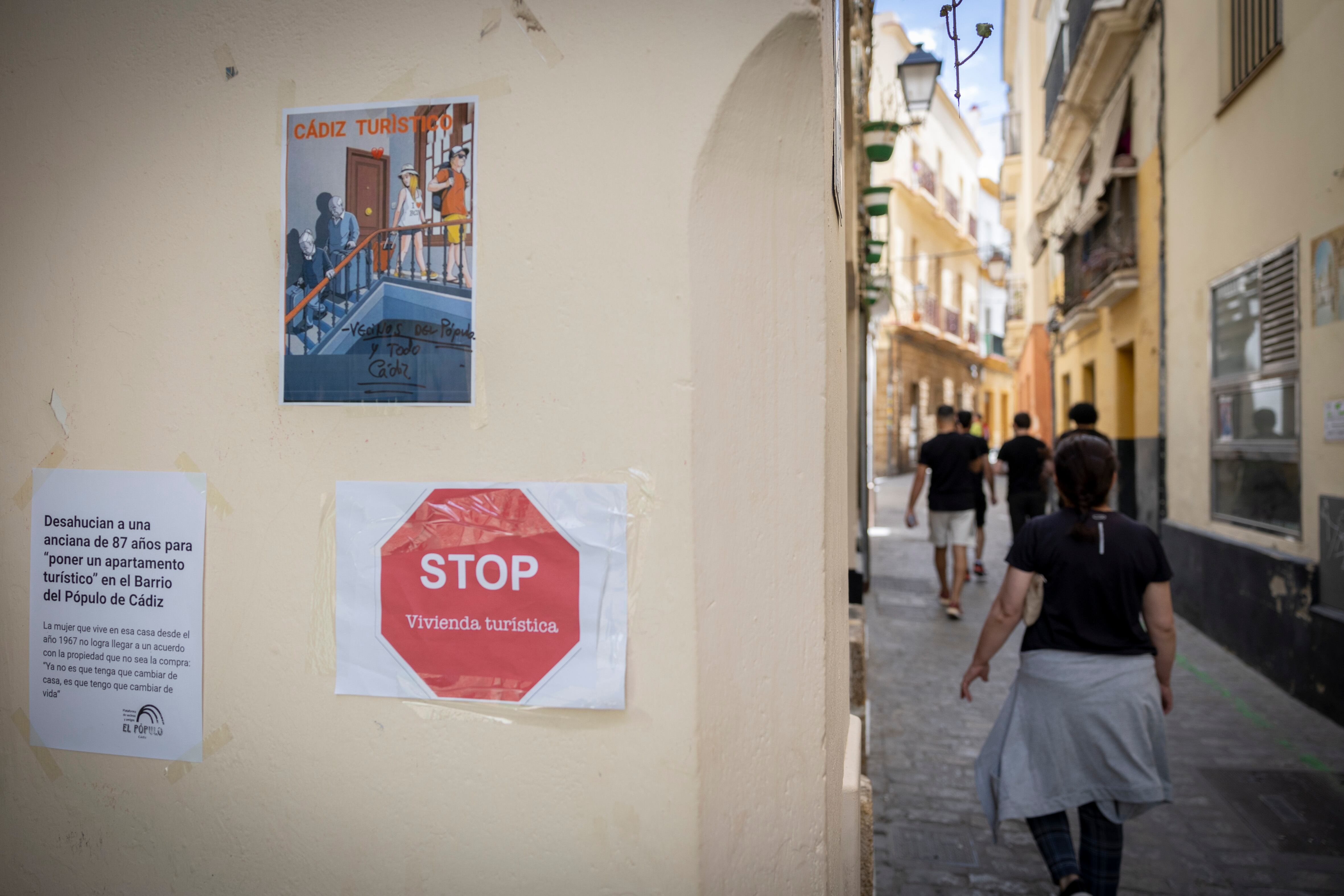 Carteles contra el turismo masivo, los desahucios y los pisos turísticos en el barrio de El Pópulo de Cádiz. 