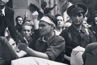 Instantes previos al asalto al Cuartel de la Montaña, en julio de 1936. En primer plano se ve a un miliciano y a un guardia de asalto (fuerzas del orden de la República) rodeados de madrileños preparados para el ataque contra los militares sublevados que se encontraban en el interior del cuartel. El dibujo de Hernández Palacios ilustra a estos personajes con las mismas vestimentas.