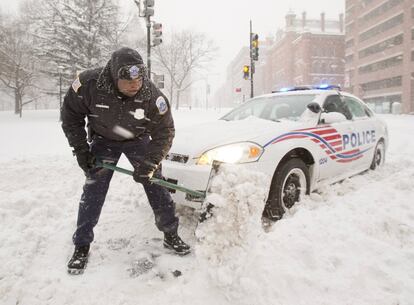 Un agente de policía quita la nieve en una calle de Washington (EE UU). 