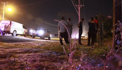 Un grupo de personas observa un cerco policial este lunes en Loma Blanca.