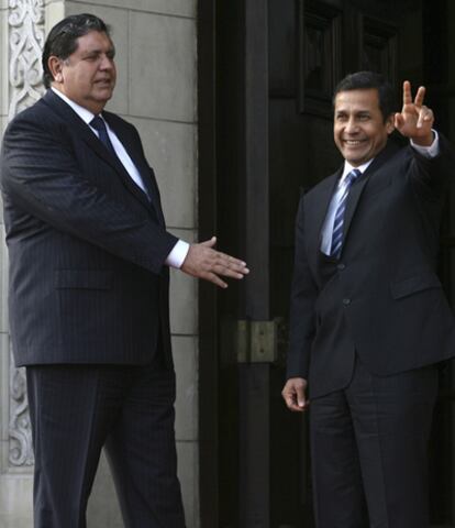 Alan García, presidente saliente de Perú, extiende la mano al presidente electo Ollanta Humala, que saluda con el signo de la victoria.