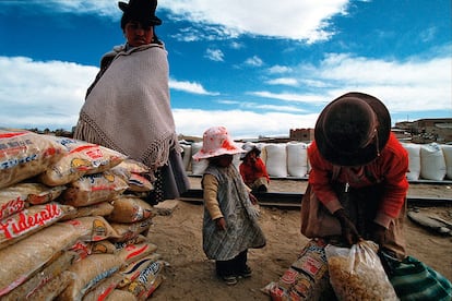 Família boliviana recebe alimentos em La Quiaca, um povoado argentino na fronteira com a Bolívia