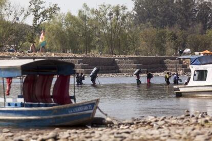 'Bagayeros' cruzan el río Bermejo desde Bolivia a Argentina cargados de mercancías.