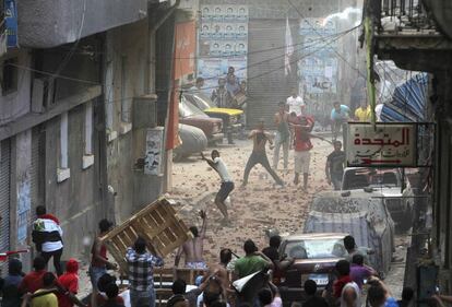 Los manifestantes anti-Morsi (abajo) y los residentes del &aacute;rea de Sidi Gaber, se enfrentan durante el avance de la manifestacion desde la plaza Tahrir hasta el palacio presidencial. 