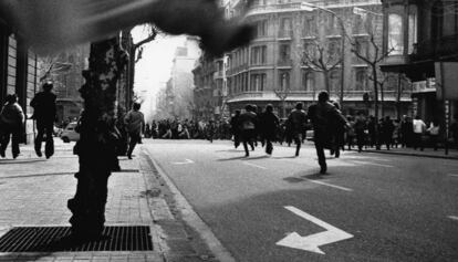 Una de les imatges de la mostra, amb gent corrent davant la policia.