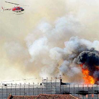 Un helicóptero supervisa las labores de extinción del incendio.