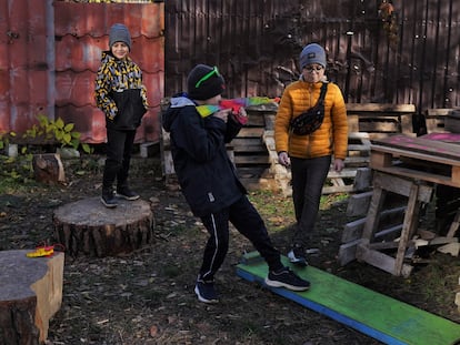 Un grupo de niños -a la derecha, Ostap- jugaban el martes junto a palés y troncos que sus padres preparan como leña para pasar el invierno en Irpin.