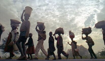 Refugiados ruandeses caminan con sus pertenencias.