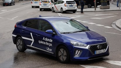 Un VTC circulando frente a varios taxis, en Madrid.