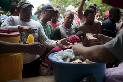 Inmigrantes cubanos reciben comida en la frontera que divide Costa Rica y Nicaragua.