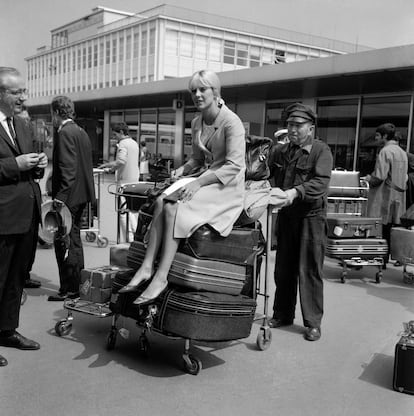 La cantante Sylvie Vartan descansa sobre su equipaje en el aeropuerto de Orly, París, en 1965.