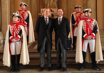 Costos with his husband Michael Smith, posing with a posse of halberdiers at the Royal Palace in Madrid.