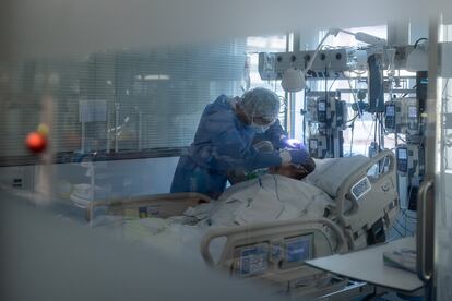 A health worker with a Covid-19 patient in Barcelona‘s Clínic Hospital.