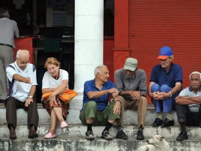 Um grupo de idosos conversa na rua.