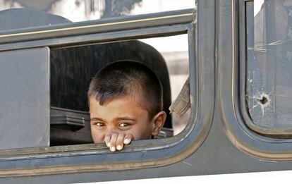 Un joven refugiado sirio se asoma por la ventana de un autobús mientras otros refugiados se preparan para abandonar la capital libanesa, Beirut, antes de emprender su regreso a Siria.