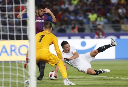El centrocampista del Sevilla Roque Mesa cae ante el barcelonista Luis Suárez, en presencia del portero Vaclik.