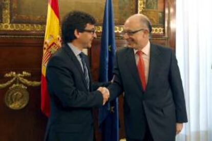 El ministro de Hacienda y Administraciones Públicas, Cristóbal Montoro (d), saluda al titular de Finanzas y Función Pública de Andorra, Jordi Cinca (i), durante el encuentro que han mantenido esta mañana en la sede del Ministerio, en Madrid.