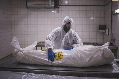 Un trabajador de una morgue prepara el cuerpo de un fallecio por coronavirus para su funeral, en Pretoria (Sudáfrica).