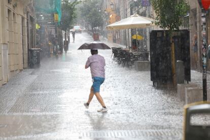 Una persona se protege de la lluvia este miércoles en Madrid.