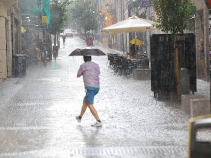 Una persona se protege de la lluvia este miércoles en Madrid.