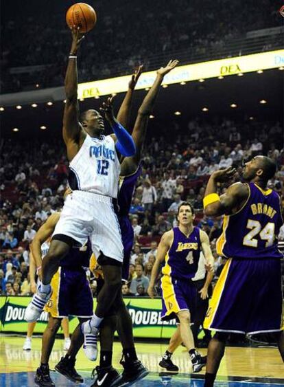 Dwight Howard lanza a canasta ante la mirada de Kobe Bryant