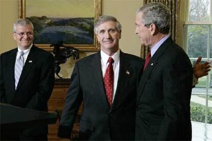 Andrew Card, en el centro, abraza al presidente George W. Bush, ante la presencia del nuevo jefe de Gabinete, Josh, Bolten.