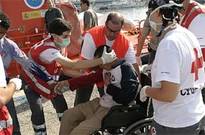 Médicos de la Cruz Roja atienden por un mareo a uno de los 34 inmigrantes marroquíes interceptados cerca de Motril.