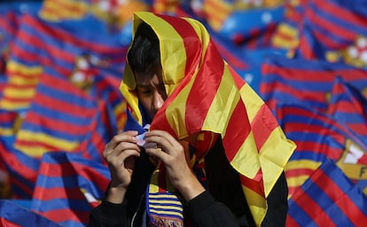 Un aficionado del Barça se cubre del sol con una estelada