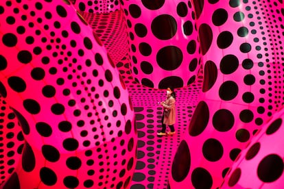 Una mujer camina a través de la obra ‘Un ramo de amor que vi en el universo’, por Yayoi Kusama, durante la rueda de prensa de una retrospectiva de la artista japonesa en el museo Martin Gropius Bau, en Berlín (Alemania), el 22 de abril de 2021. La exposición estuvo abierta desde el 23 de abril hasta el 15 de agosto de 2021.