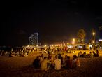 Jóvenes de botellón en la playa de la Barceloneta este verano.