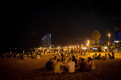 Jóvenes de botellón en la playa de la Barceloneta este verano.