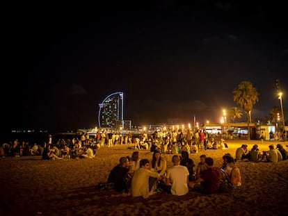 Jóvenes de botellón en la playa de la Barceloneta este verano.