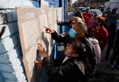 Ciudadanos buscan la mesa de votación asignada para depositar su voto, hoy en Bogotá (Colombia)