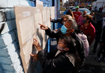 Ciudadanos buscan la mesa de votación asignada para depositar su voto, hoy en Bogotá (Colombia)