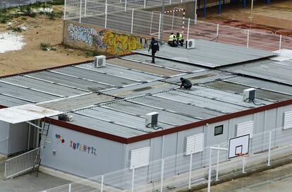 Operarios trabajan en los tejados de los barracones del colegio 103 de Valencia.