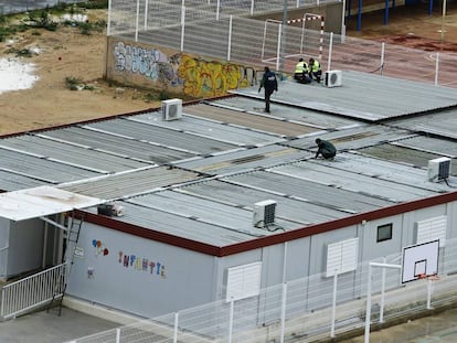 Operarios trabajan en los tejados de los barracones del colegio 103 de Valencia.