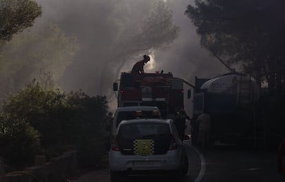 En la zona del siniestro, camiones de bomberos, cubas y coches policiales cortan la carretera rodeados de humo.
