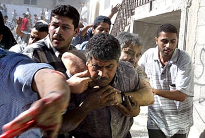 Un grupo de palestinos traslada a un herido en el ataque contra el jeque Yasín, líder espiritual de Hamás.
