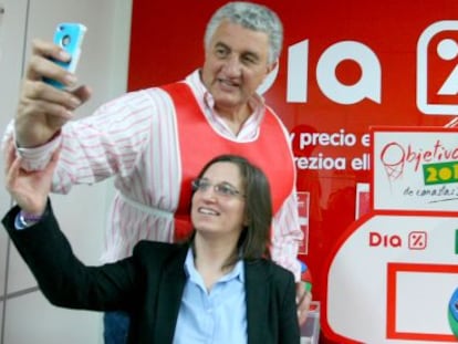 Fernando Romay posa junto a una joven ante una de las cajas de recogida de alimentos. 