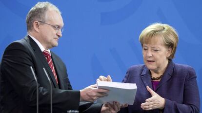 El presidente de economistas del Gobierno alem&aacute;n, Schmidt, entrega el informe anual con sus recomendaciones a  Angela Merkel. 
