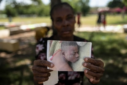 En una fotografía de julio de 2022, Silvenia Luc muestra la foto de su hijo, asesinado en enfrentamientos entre pandillas en Cité Soleil.