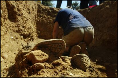 Un voluntario de la ARMH trabaja en el interior de la fosa donde se exhumaron varios restos de vecinos de Fresnedo (León), conservándose en buen estado parte sus zapatos, el 11 de julio de 2002.