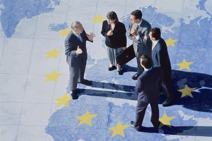 Grupo de ejecutivos de negocios de pie en un mapa con las estrellas de la UE