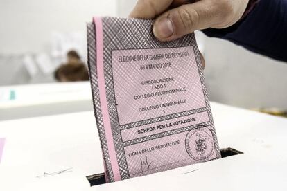 Una persona introduce su voto en una urna de un colegio electoral de Roma.