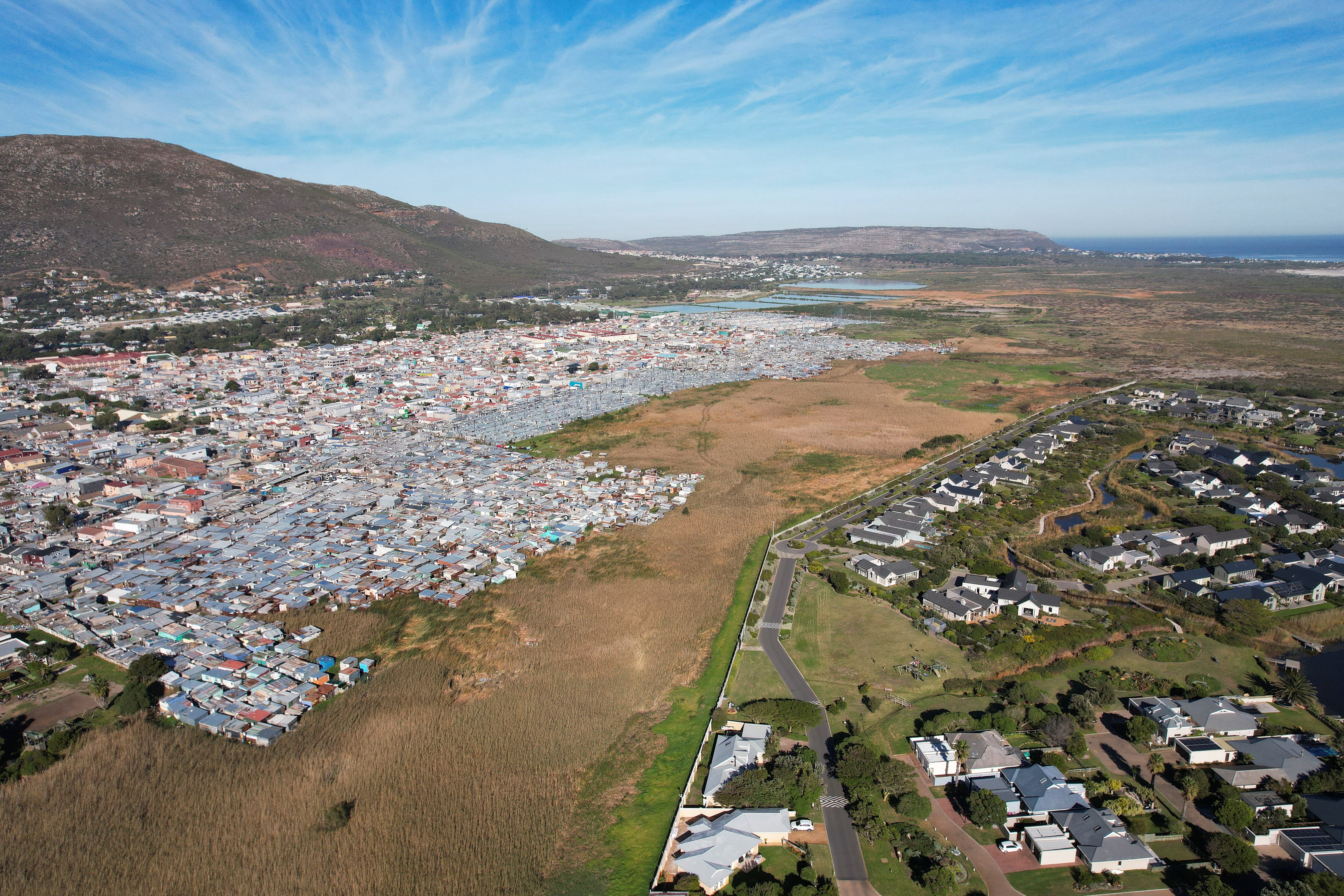 Imagen de dron tomada el día 14 que muestra el asentamiento de Masiphumelele, que se extiende por un humedal adyacente al complejo residencial Lago Michelle, en Ciudad del Cabo. 