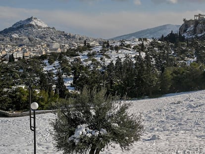 Gente que camina en la colina Pnyx cubierta de nieve en Atenas después de una tormenta de nieve el 25 de enero de 2022. Grecia amplió el feriado general hasta el 26 de enero, para evitar movimientos de personas ya que Grecia vive un frente frío con fuertes nevadas y temperaturas muy bajas.