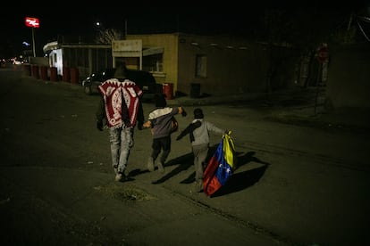 A Venezuelan migrant walks with his children in the streets of Ciudad Juarez. 