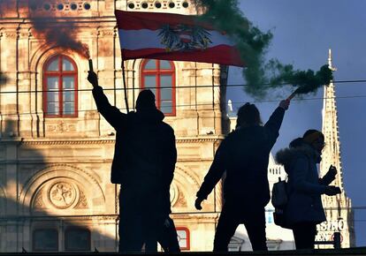 Varios manifestantes sujetan bengalas de humo durante una manifestación en contra de las medidas tomadas para frenar la pandemia, este sábado en Viena (Austria).