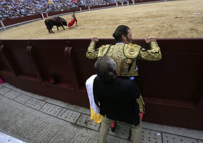 El apoderado del diestro jerezano Juan José Padilla apaña la taleguilla del torero en los momentos previos al momento de la verdad. El toro de El Pilar le espera.